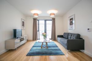 a living room with a couch and a tv at Grand Canal Square Apartments in Dublin