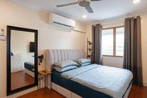 1 dormitorio con cama con espejo y ventana en Cozy-SJ-Family Holidays-Work-BBQ-Tea ceremony-Engagement en Subang Jaya