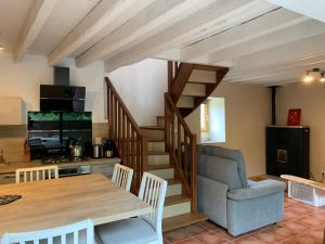 a living room with a wooden table and a staircase at gîte du Cady in Casteil