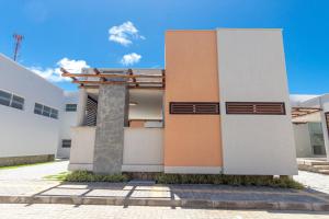 a facade of a building with a blue sky at Flamingos Pipa #03 - Casa na Praia por Carpediem in Pipa