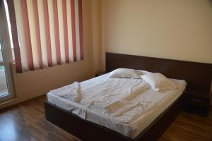 un letto con lenzuola e cuscini bianchi in una camera da letto di TRIUMF a Costinesti