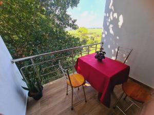 un tavolo rosso e sedie sul balcone di Jungle Lodge a Udawalawe