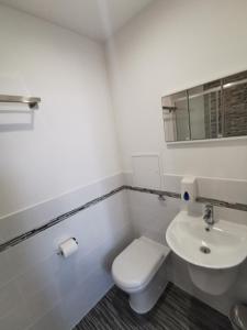 a white bathroom with a toilet and a sink at The Kerswell Hotel in Morecambe