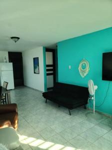 a living room with a black couch and a blue wall at Caracoles Breeze Apartments in Islote