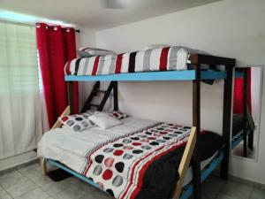 Caracoles Breeze Apartments في Islote: غرفة نوم بسريرين بطابقين في غرفة