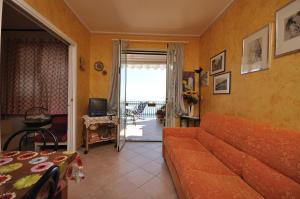 a living room with a couch and a television at Villa Ridente Maria in Gioiosa Marea