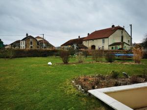 a yard with houses in the background and a yard with grass at Chez Elodie in Pressigny