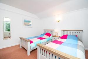2 camas en una habitación con paredes blancas en Greenacres, en Llanbedrog