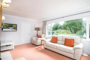 a living room with a white couch and a window at Greenacres in Llanbedrog