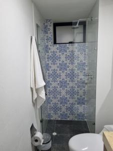 La salle de bains est pourvue d'une douche avec du carrelage bleu et blanc. dans l'établissement New Comfortable Apartments in La Candelaria, Bogotá, à Bogotá