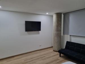 - un salon avec un canapé et une télévision murale dans l'établissement New Comfortable Apartments in La Candelaria, Bogotá, à Bogotá