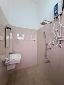 un bagno con doccia, lavandino e specchio di Jungle Lodge a Udawalawe