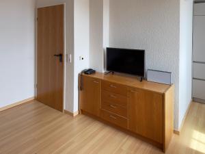 ウィトデュンにあるFerienwohnung *Gaubenkieker*の室内の木製ドレッサーのテレビ付