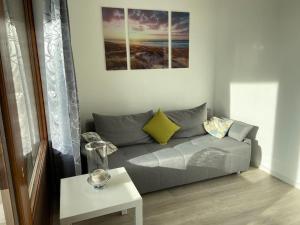 un soggiorno con un divano grigio e un tavolo di Wasserblick, in 3 Min am Strand a Heiligenhafen