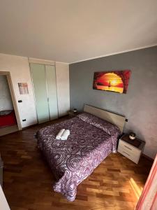 een slaapkamer met een bed met een paarse deken bij APPARTAMENTO PICCOLO SCRIGNO in Venaria Reale