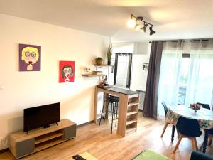 圖盧茲的住宿－Chez Sandra et Rach，客厅配有桌子和书桌及电视