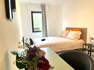 圖盧茲的住宿－Chez Sandra et Rach，小房间,配有床和鲜花桌