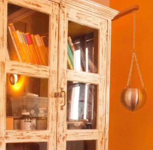 a wooden cabinet with a glass door with books at Tauglerei Appartement Enzian in den Zauberbergen in Sankt Koloman