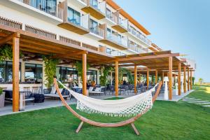 a hammock on the lawn in front of a hotel at AP Cabanas Beach & Nature - Adults Friendly in Cabanas de Tavira