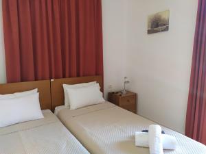 two beds in a small room with red curtains at Papas Studios in Skala Marion