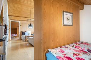 Haus Sonnenhang Wohnung 3 في Stiefenhofen: غرفة نوم مع سرير وغرفة معيشة