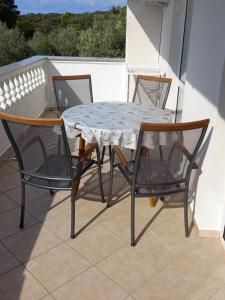 a table and four chairs on a balcony at Apartments Makaus in Rab