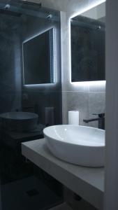 ein Badezimmer mit einem weißen Waschbecken und einem Spiegel in der Unterkunft Cinema Rooms Fiera Verona in Verona