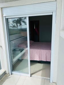 a sliding glass door with a bed in a room at Apartamento próximo da Lucas in Atibaia