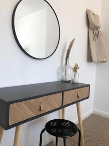 a mirror on a wall next to a desk with a chair at Sea Glass Cottage - Luxury hotel style 3 bed with hot tub in Seaham