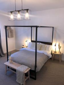 a bedroom with a large bed with a black canopy at Sea Glass Cottage - Luxury hotel style 3 bed with hot tub in Seaham