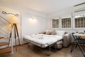 een witte kamer met een bed en een tafel bij Modern Two Level Apartment in the Heart of Athens in Athene