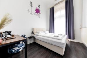 1 dormitorio con cama, escritorio y ventana en Adagio Hostel Basilica, en Budapest