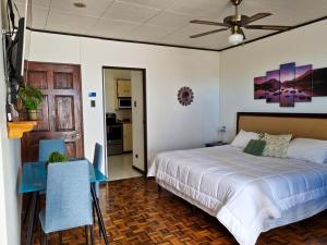 1 dormitorio con 1 cama, mesa y sillas en Casa Jardin del Mango en San José