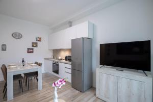 une cuisine avec une grande télévision et une table dans l'établissement Santacroce lovely apartment in Florence, à Florence