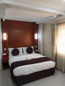 Nairobi Glory Palace Hotel Ltd في نيروبي: غرفة نوم بسرير كبير في غرفة الفندق