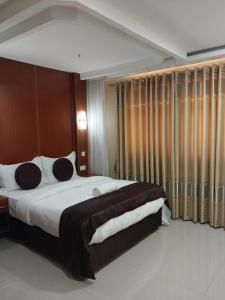 Nairobi Glory Palace Hotel Ltd في نيروبي: غرفة نوم بسرير كبير في غرفة