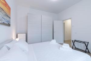 - une chambre blanche avec 2 lits et un placard dans l'établissement SANTACROCE suite-Hosted by Sweetstay, à Florence