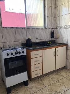 a kitchen with a stove and a counter top at excelente apartamento completo in Pelotas