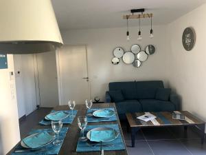 a living room with a table and a blue couch at BLUE DREAM in Juan-les-Pins