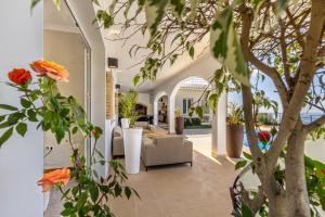 un vestíbulo de una casa con sofá y flores en Luxury villa with private heated pool, garden and views of the sea and mountains., en Arco da Calheta