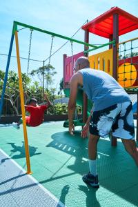 a man is playing on a playground at Monthez Hotel & Eventos in Brusque