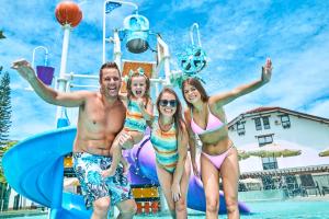 a group of three people in bathing suits at a pool at Monthez Hotel & Eventos in Brusque