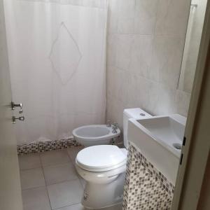 a white bathroom with a toilet and a sink at San Luis zona Shopping/ centro in San Luis
