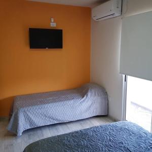a bedroom with a bed and a tv on the wall at San Luis zona Shopping/ centro in San Luis
