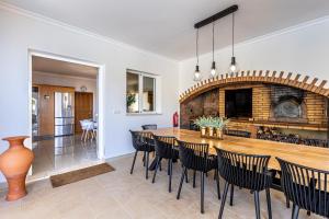 a dining room with a fireplace and a table and chairs at Luxury villa with private heated pool, garden and views of the sea and mountains. in Arco da Calheta