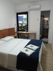 een slaapkamer met een groot bed en handdoeken bij Requinte Hotel in Sao Paulo