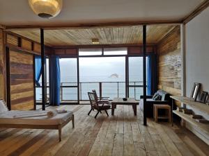 ein Wohnzimmer mit Meerblick in der Unterkunft Nirima Room in SantʼAna