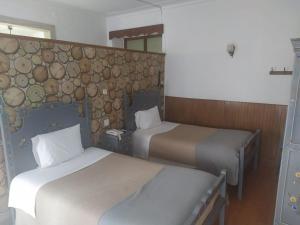 a room with two beds and a stone wall at Residencial Carvalho in Estremoz