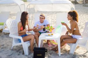 grupa ludzi siedzących przy stole na plaży w obiekcie Agua Dorada Beach Hotel By Lidotel w mieście El Agua