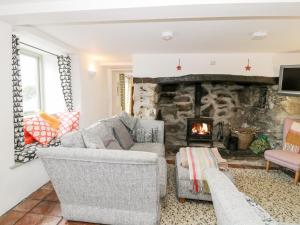 a living room with a stone fireplace at 2 Pant Heulog in Dyffryn